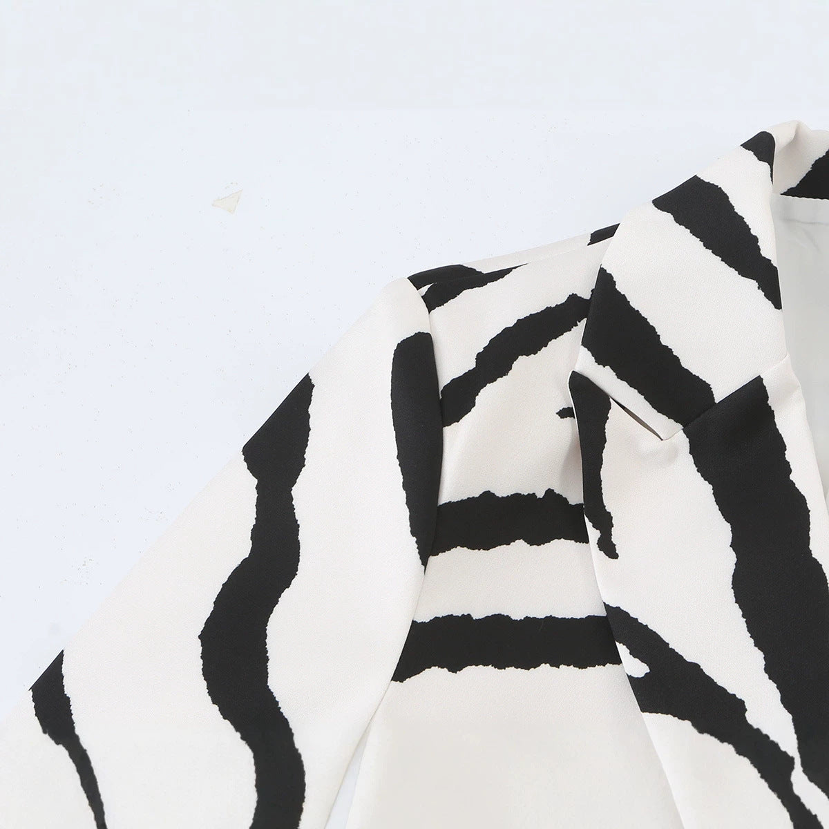 Close-up of the zebra-print blazer's shoulder and notched lapel.