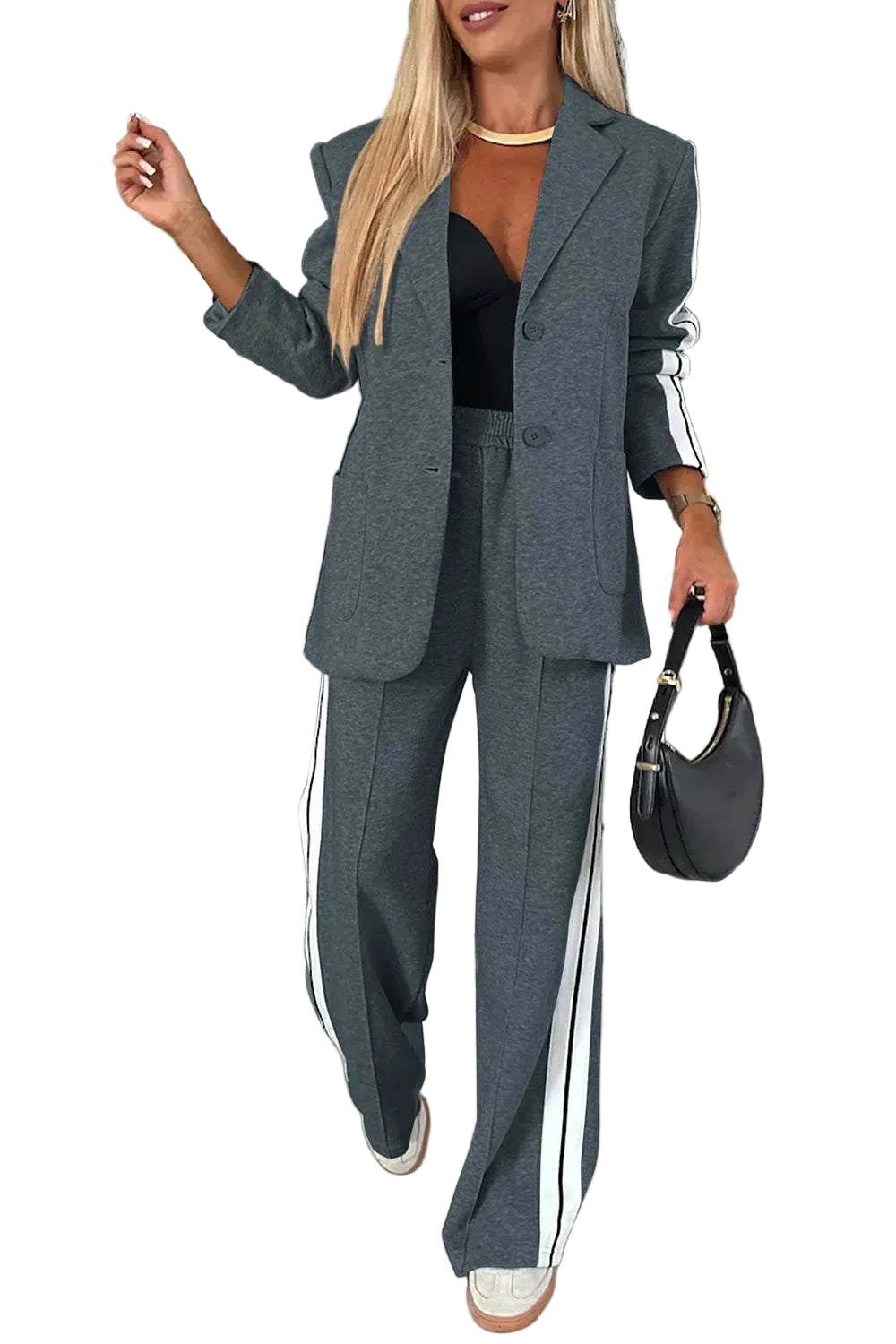 Model wearing a dark gray blazer and wide-leg pants with white striped sleeve and leg panels, front view.