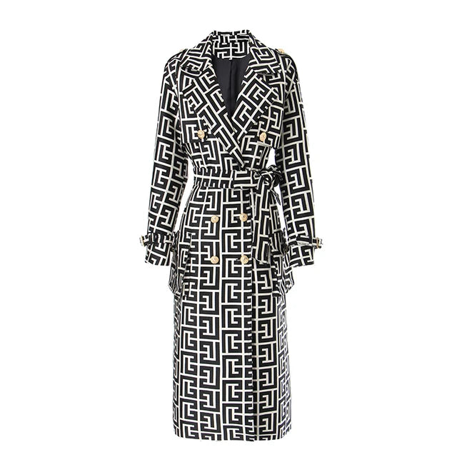 Black and white geometric double-breasted trench coat with gold buttons and a waist tie, front view.