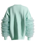 Back view of a mint green crewneck sweater with layered sheer sleeve ruffles and ribbed hem.