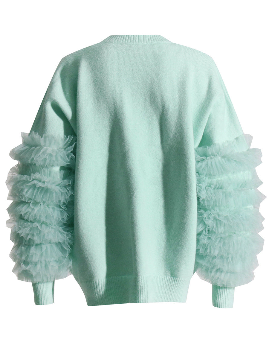 Back view of a mint green crewneck sweater with layered sheer sleeve ruffles and ribbed hem.
