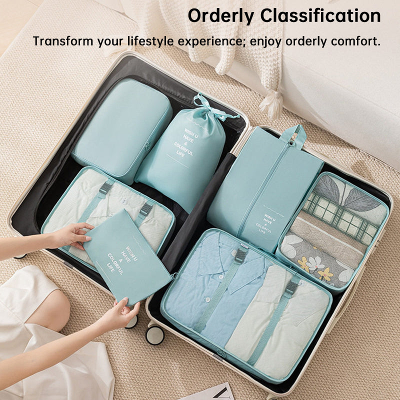 Open suitcase filled with mint packing cubes and travel bags containing folded clothes, shoes, and toiletries.