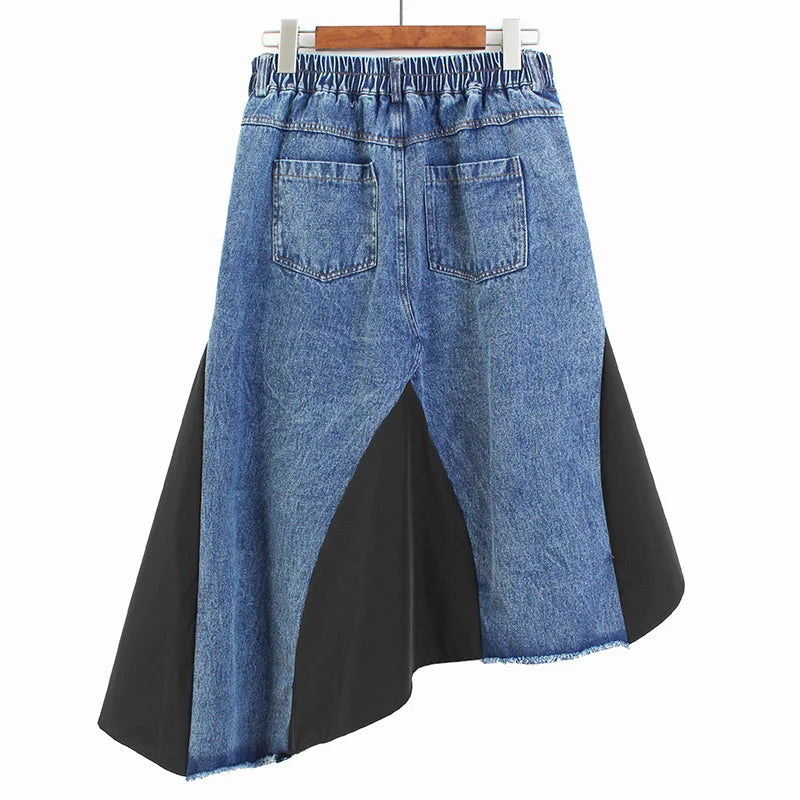 Back view of a blue denim skirt with rear pockets, black inset panels, and an asymmetric raw hem.