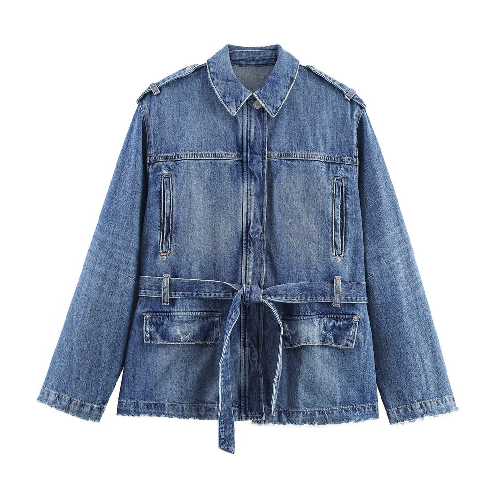 Blue denim jacket with a pointed collar, epaulets, chest zippers, flap pockets, and waist tie, front view.