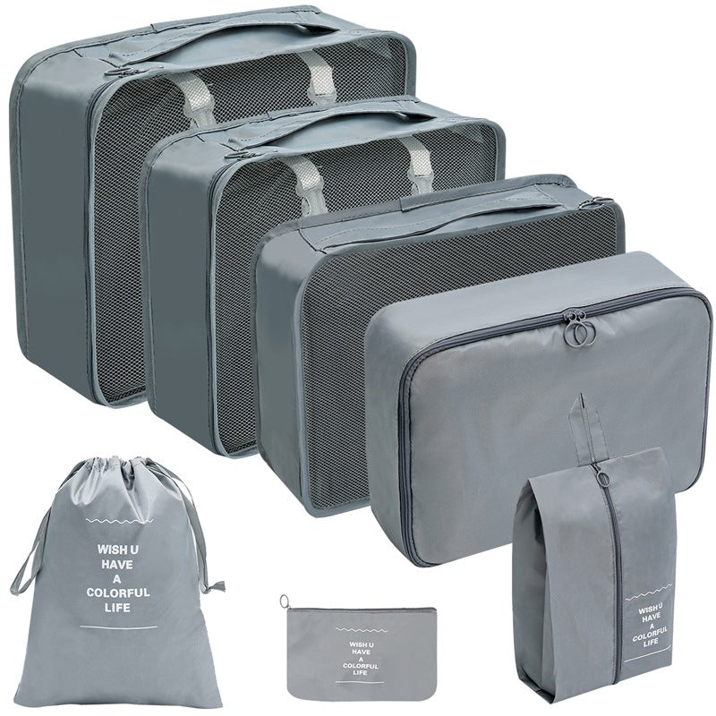 Gray travel organizer set with three mesh-top packing cubes, zippered cases, a drawstring bag, and a flat pouch.