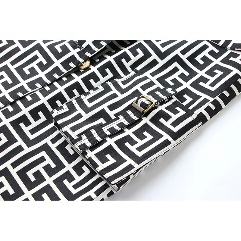 Close-up of the geometric trench coat's gold buckle cuff strap and matching pattern.