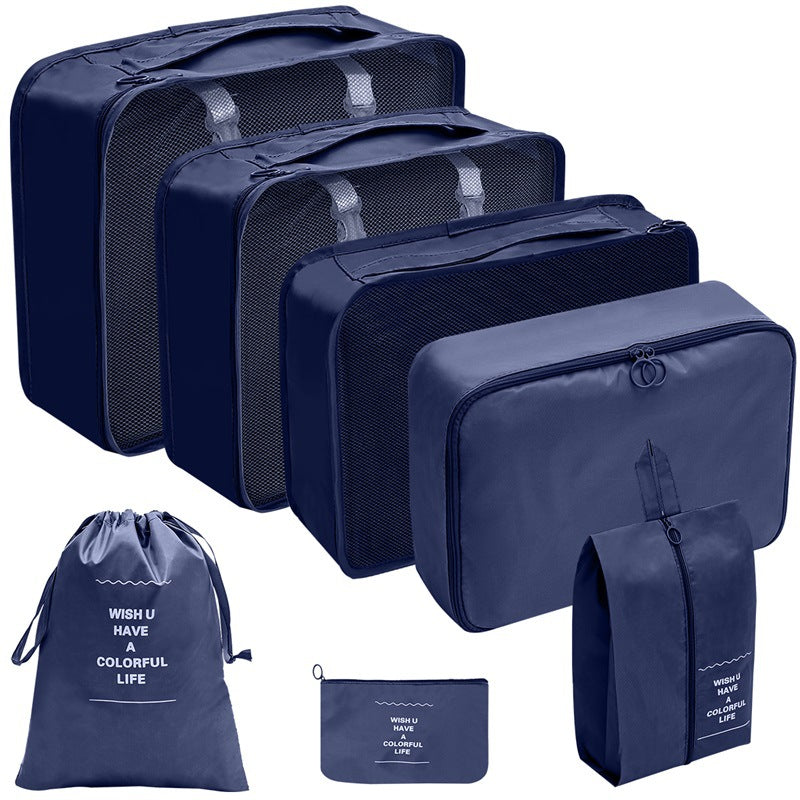 Navy travel organizer set with three mesh-top packing cubes, zippered cases, a drawstring bag, and a flat pouch.