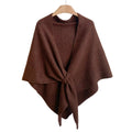 Brown knitted wrap shawl with long front ties crossed together, displayed on a hanger.