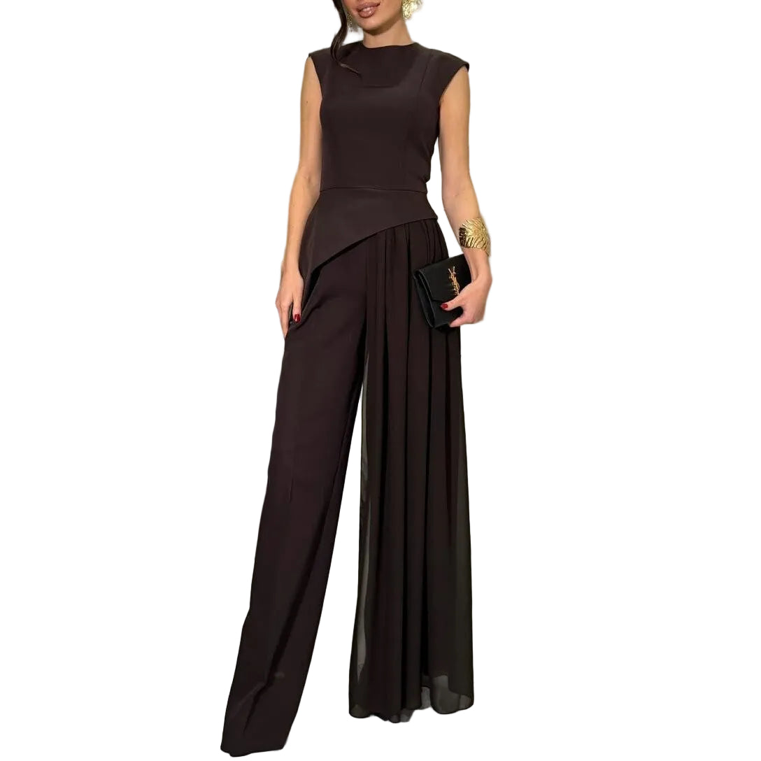 Model wearing a black sleeveless asymmetric top and wide-leg pants with a long sheer overlay, front view.