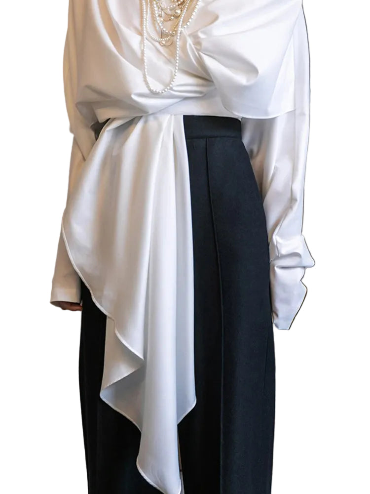 Close-up of the white wrap top's gathered waist and long asymmetric draped tie.
