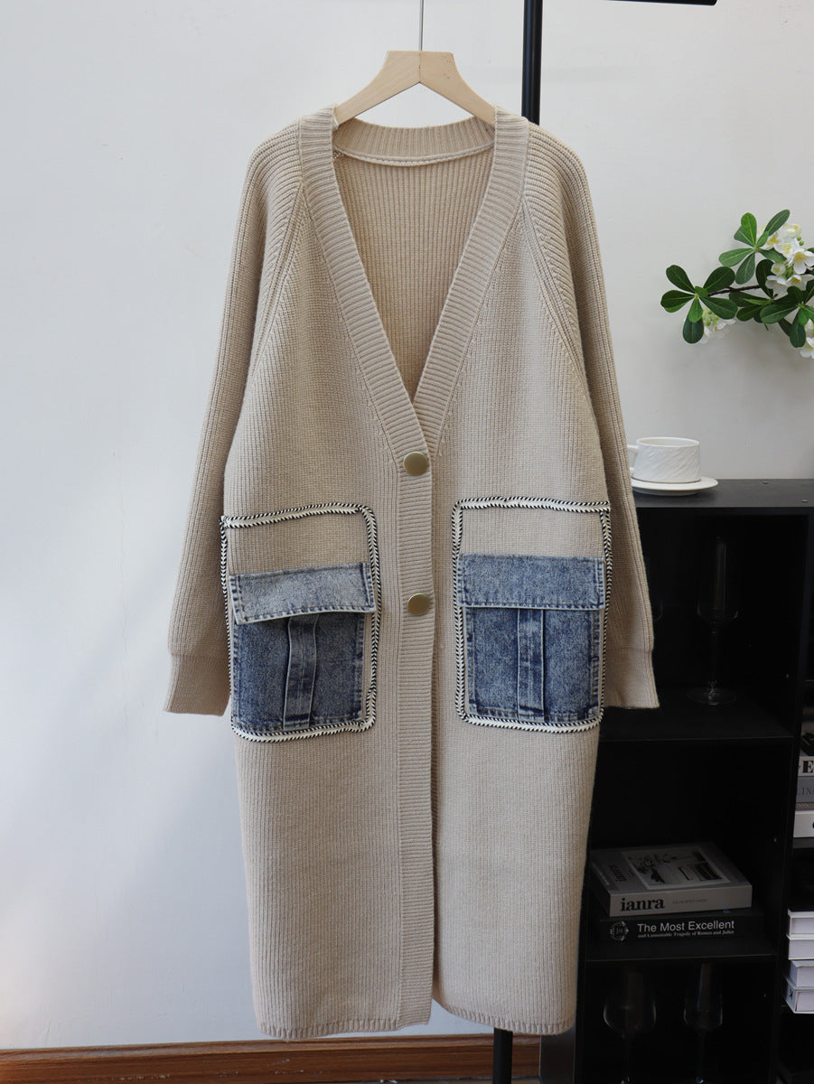 Beige longline V-neck cardigan with gold buttons and blue denim flap pockets, hanging front view.