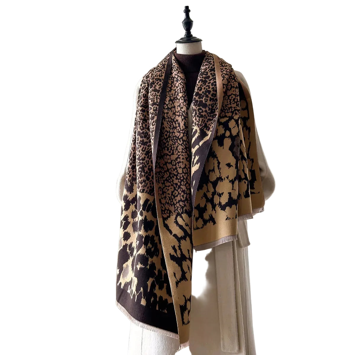 Tan and black mixed-scale leopard-print scarf with short fringe draped loosely around a mannequin's neck.