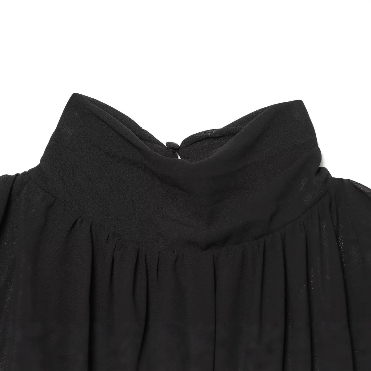 Close-up of the black blouse's high collar, back button closure, and gathered fabric.