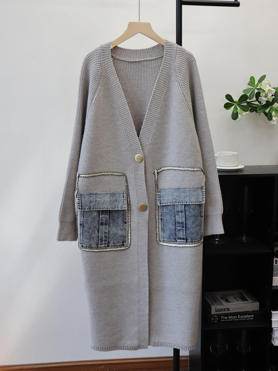 Gray longline V-neck cardigan with gold buttons and blue denim flap pockets, hanging front view.