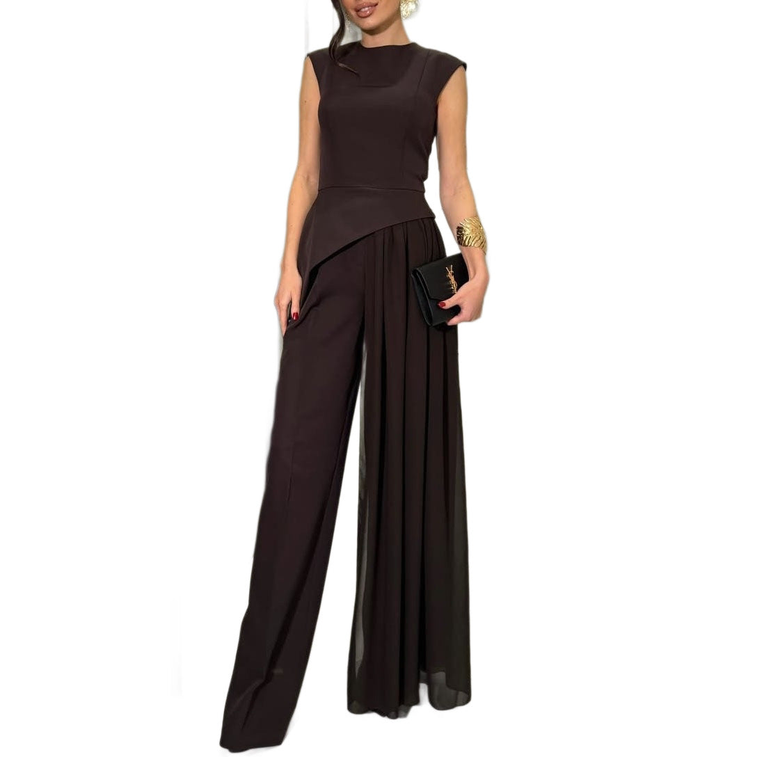Model wearing a black sleeveless asymmetric top and wide-leg pants with a long sheer overlay, front view.