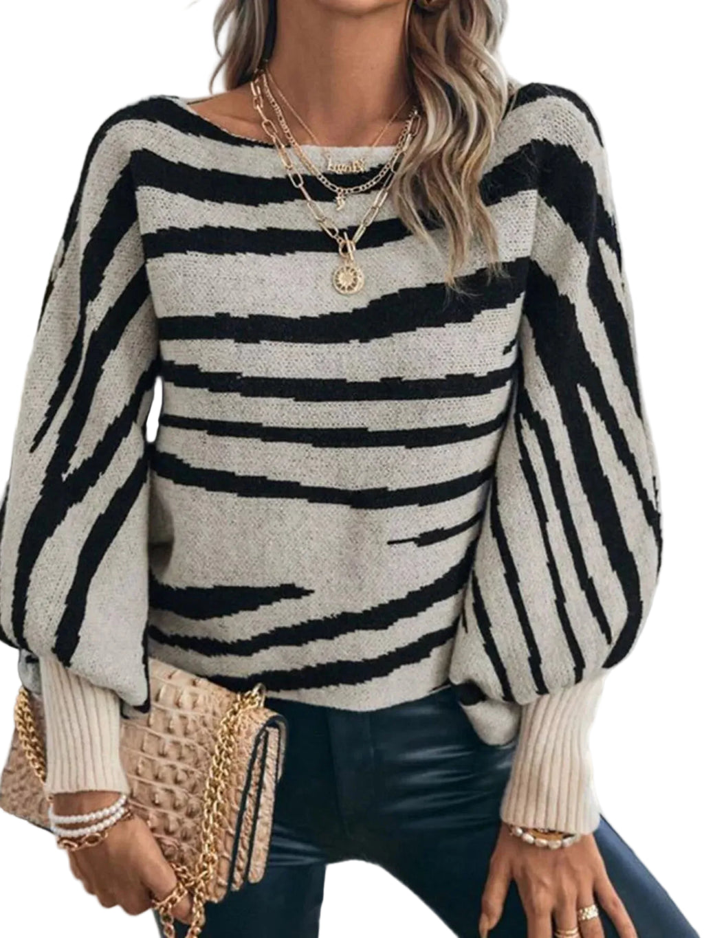 Model wearing a black and cream striped sweater with a wide neckline and long balloon sleeves, front view.