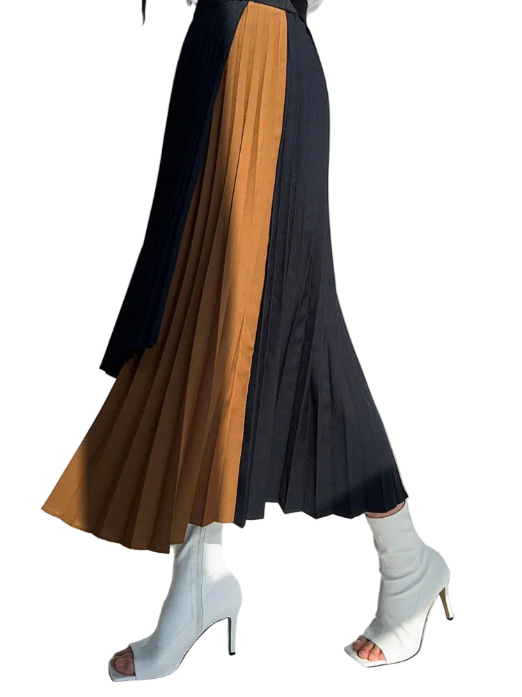 Side view of a black pleated midi skirt with a long caramel panel, worn with white ankle boots.