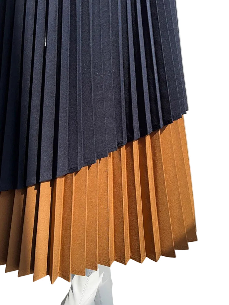 Close-up of black and caramel pleats and the layered asymmetric skirt hem.