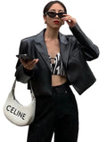 Model wearing a black shiny cropped jacket with notched lapels and long sleeves, front view.
