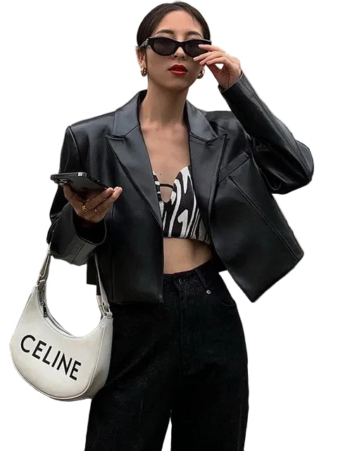 Model wearing a black shiny cropped jacket with notched lapels and long sleeves, front view.