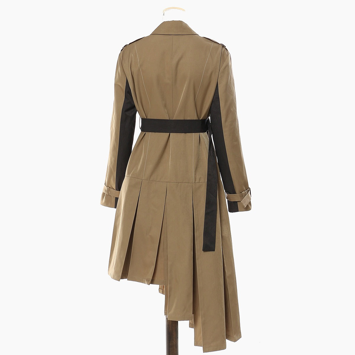 Back view of a tan dress with black sleeve panels, black waist belt, and asymmetric pleated skirt.