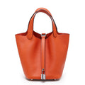 Orange pebbled bucket bag with twin handles, a front fastening strap, and a silver-tone padlock, front view.