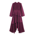 Burgundy long-sleeve dress with a pleated bodice, shoulder ruffles, and tiered asymmetric skirt, front view.