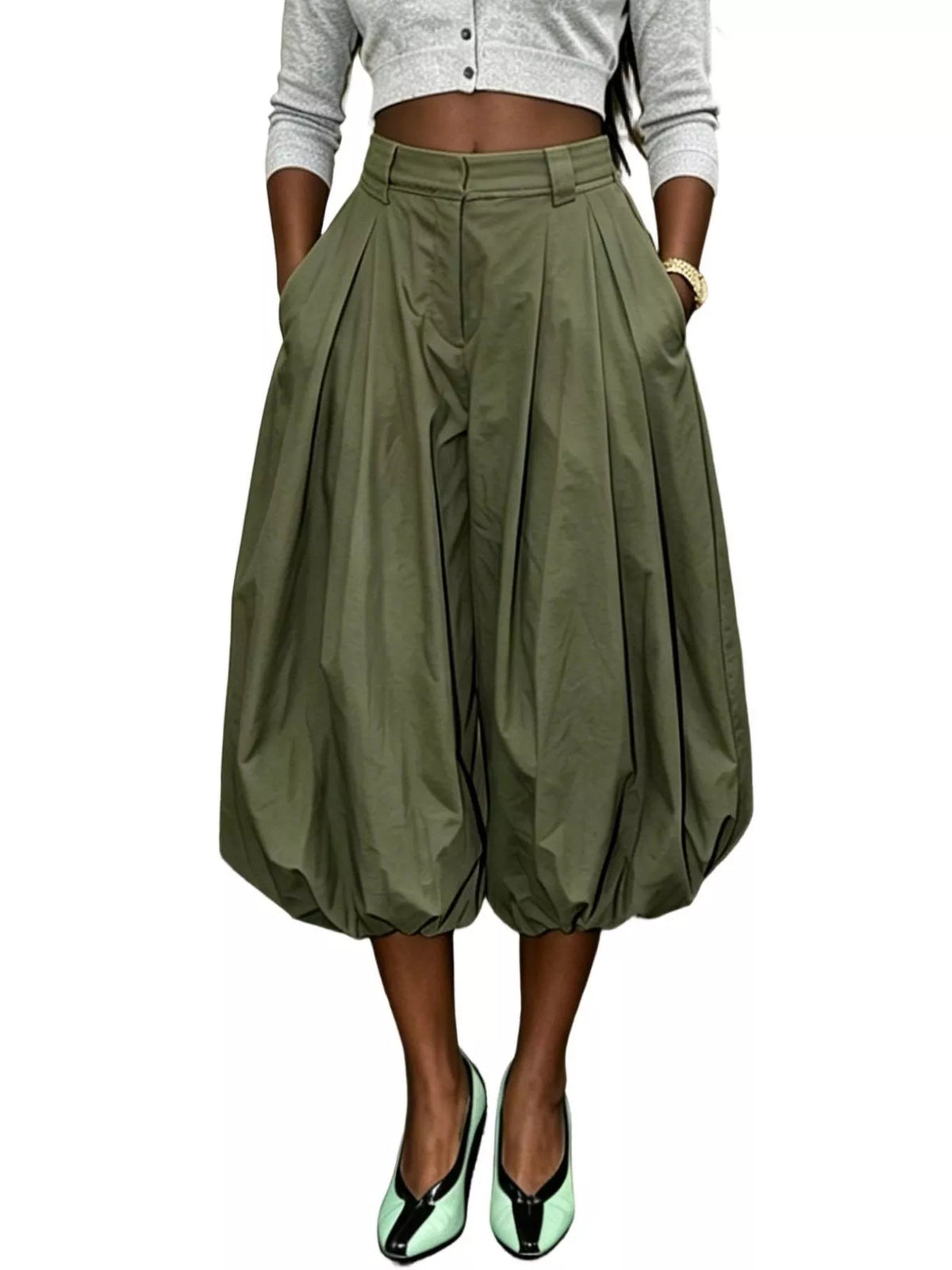 Model wearing olive green high-waist balloon pants with deep pleats and gathered cropped hems, front view.