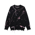 Black distressed sweater with pink accents, loose threads, and frayed neckline, cuffs, and hem, front view.