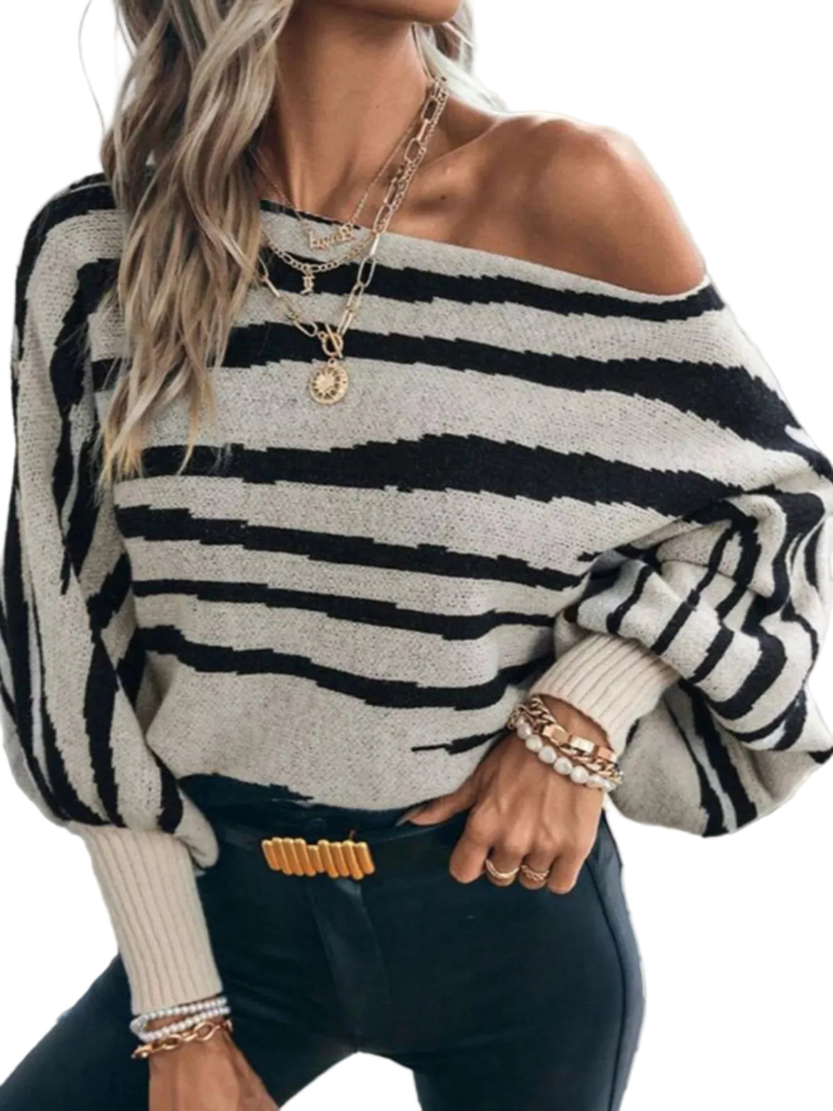 Angled view of a black and cream striped sweater worn off one shoulder, with long balloon sleeves.