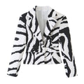 Black and white zebra-print cropped jacket with notched lapels and a matching buckle belt, front view.