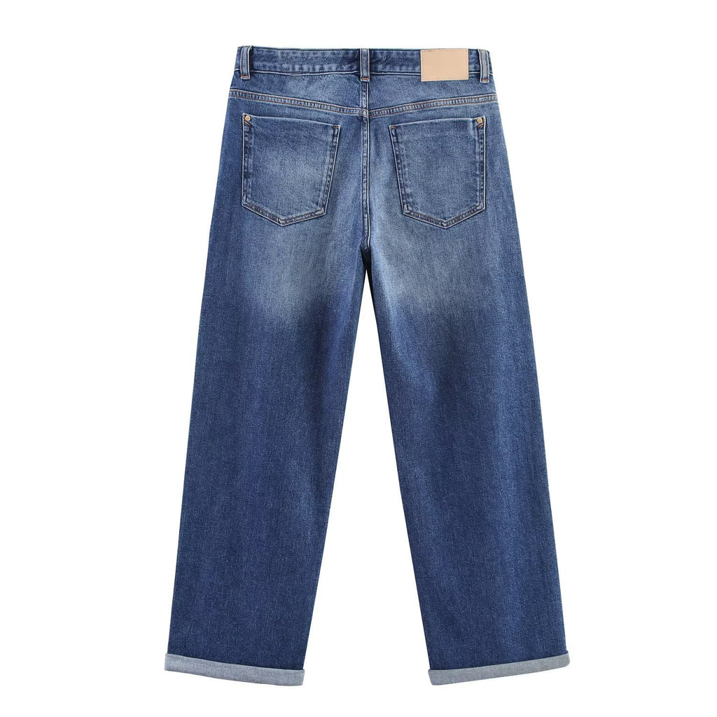 Back view of blue wide-leg jeans with two patch pockets, a tan waistband patch, and cuffed hems.