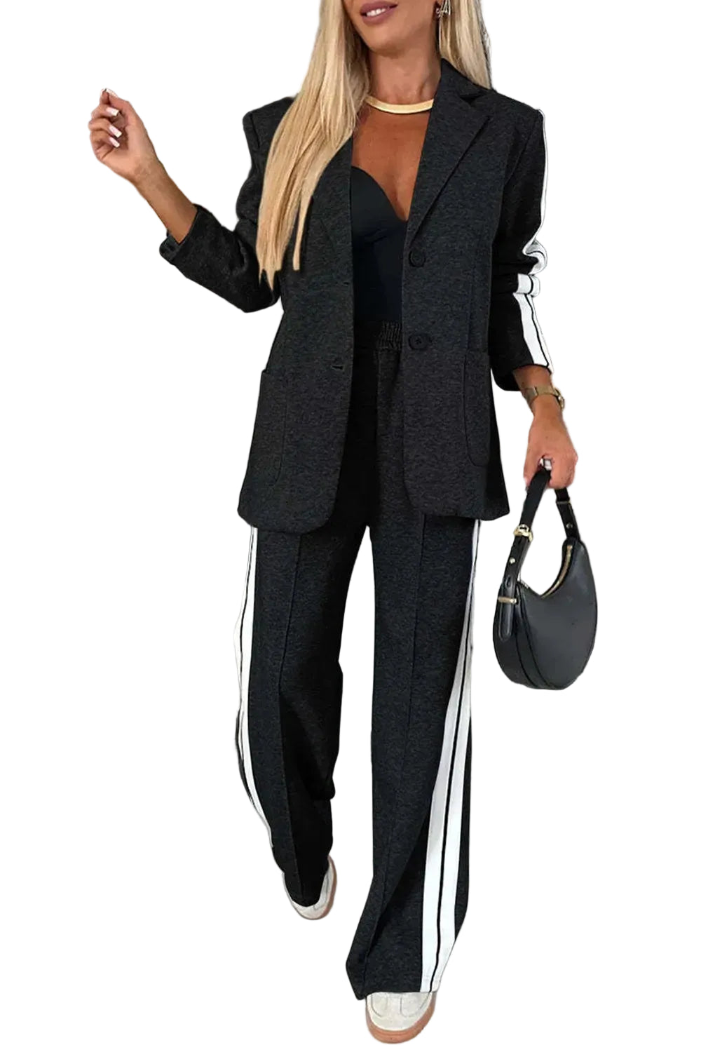 Model wearing a black blazer and wide-leg pants with white striped sleeve and leg panels, front view.