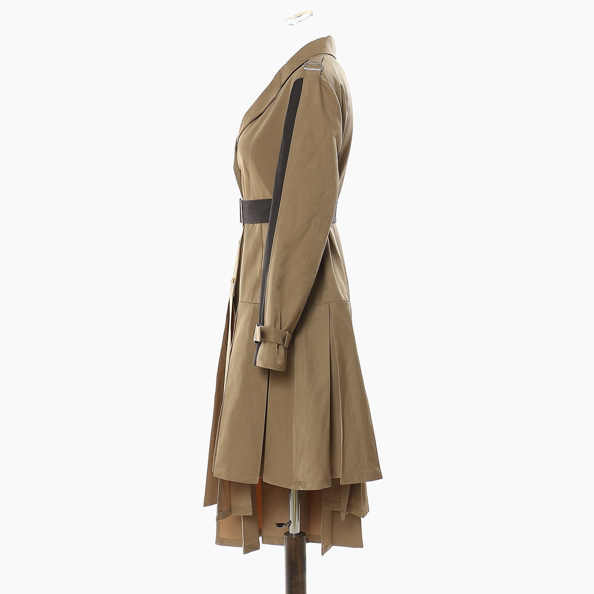 Side view of a tan belted dress with black sleeve panels and an asymmetric pleated skirt.