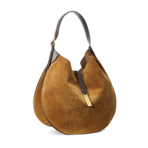 Angled view of a tan rounded shoulder bag with a dark adjustable strap and gold-tone front clasp.