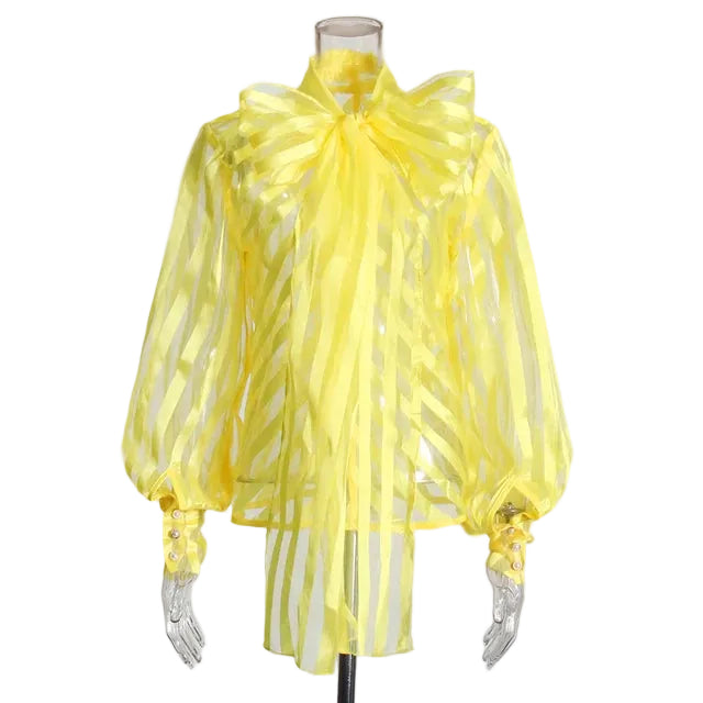 Yellow sheer striped blouse with an oversized neck bow and balloon sleeves on a mannequin, front view.