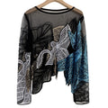 Black sheer long-sleeve top with silver, gold, and teal floral sequins, hanging view.