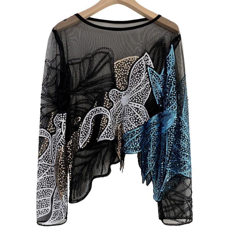 Black sheer long-sleeve top with silver, gold, and teal floral sequins, hanging view.