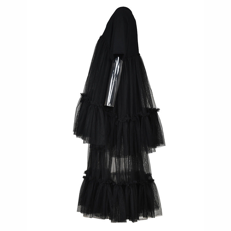 Side view of a black short-sleeve dress with sheer mesh panels and tiered ruffles on a mannequin.