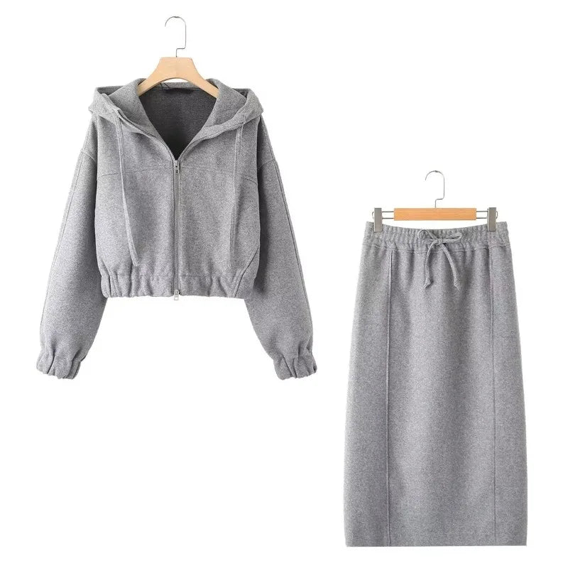 Gray cropped zip-front hoodie and matching drawstring midi skirt displayed on hangers, front view.