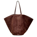 Brown curved tote with long slim shoulder straps, a center seam, and a suede-like finish, front view.