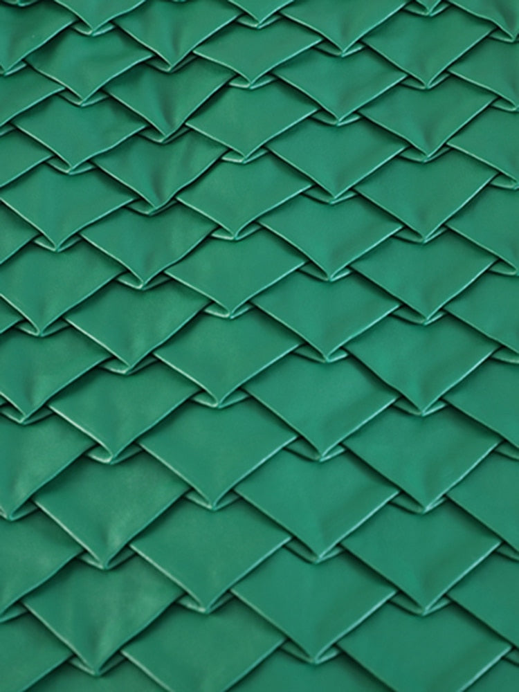 Close-up of overlapping green diamond-shaped panels on a textured skirt.