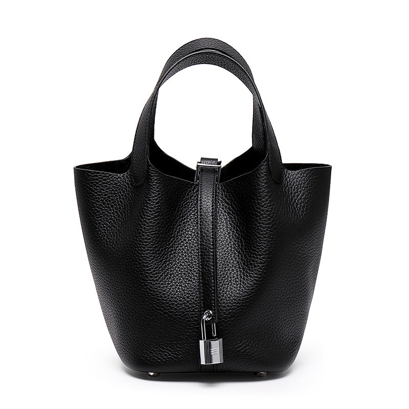 Black pebbled bucket bag with twin handles, a front fastening strap, and a silver-tone padlock, front view.