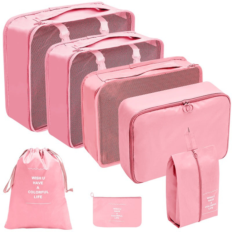 Pink travel organizer set with three mesh-top packing cubes, zippered cases, a drawstring bag, and a flat pouch.