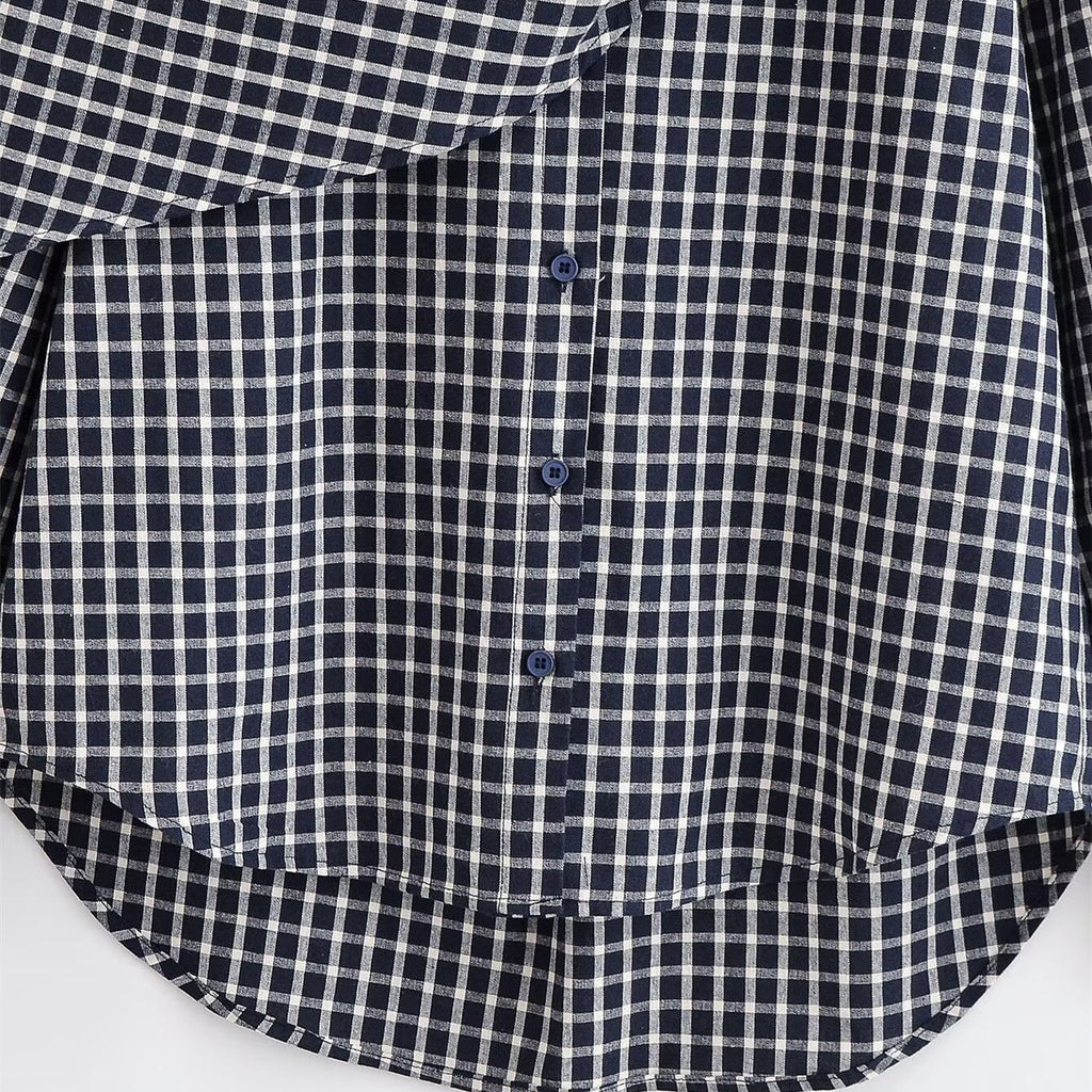 Close-up of the checked shirt's buttons and curved high-low hem.