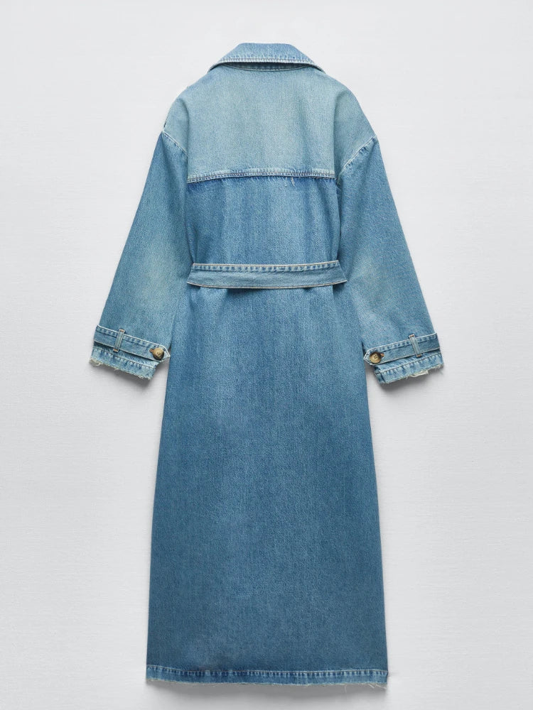 Back view of a light blue denim trench coat with a waist belt, back yoke, and cuff straps.
