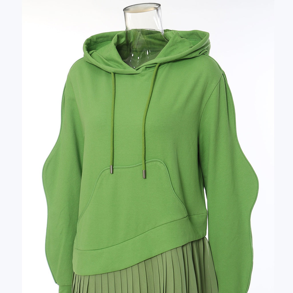 Close-up of the green hoodie dress's drawstring hood, pouch pocket, and curved sleeves.