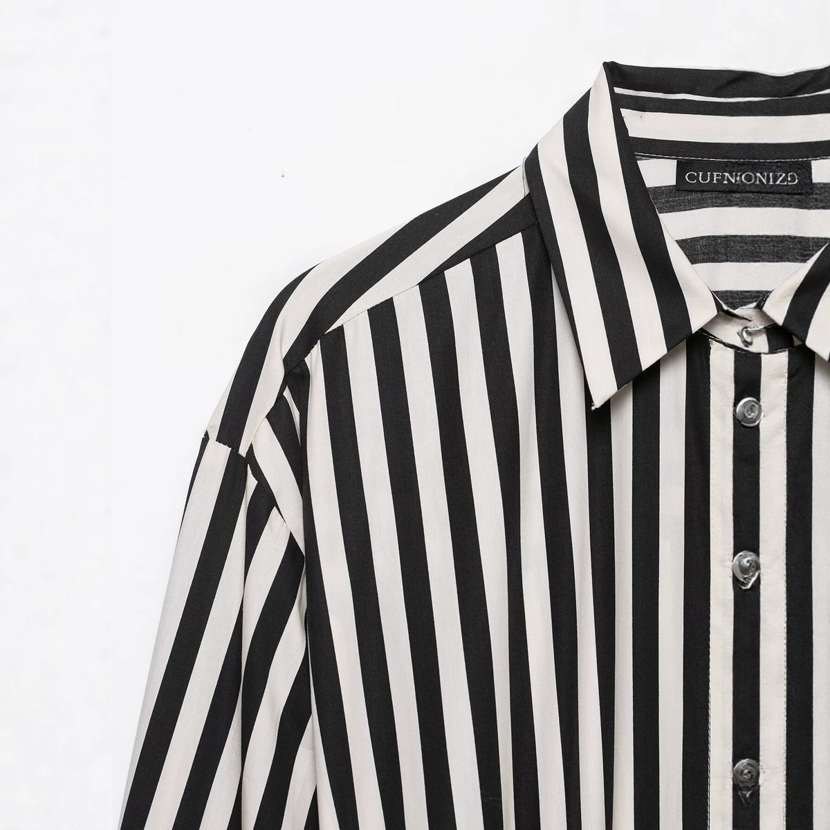 Close-up of the black and white striped shirt's pointed collar, shoulder, and buttons.