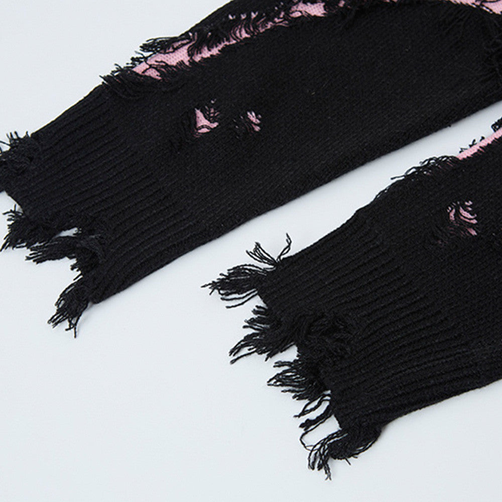 Close-up of the black distressed sweater's frayed ribbed cuffs and pink accents.
