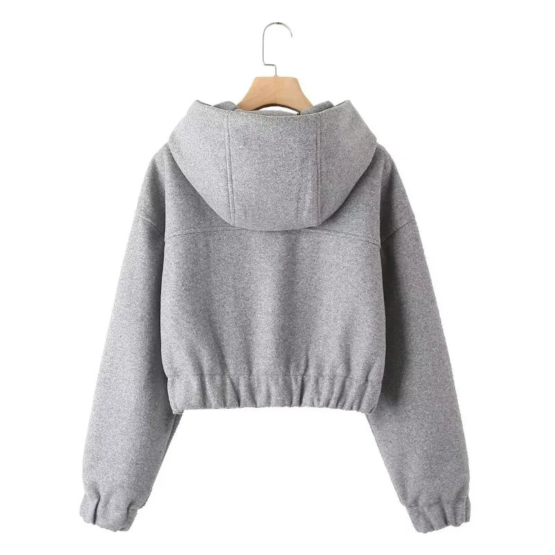 Back view of a gray cropped hoodie with a hood, gathered cuffs, and elastic hem.
